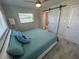 Bedroom features a sliding barn door to ensuite bathroom, window, and wood-look floors at 22214 Felton Ave, Port Charlotte, FL 33952