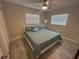 Bright bedroom with neutral walls, ceiling fan, two windows, and wood-look flooring at 22214 Felton Ave, Port Charlotte, FL 33952