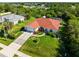 Aerial view showcasing the home's well-manicured lawn, mature landscaping, and a long driveway leading to the garage at 22378 Peachland Blvd, Port Charlotte, FL 33954