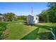 Charming backyard featuring a storage shed, vibrant plants, and well-maintained lawn with green grass at 22378 Peachland Blvd, Port Charlotte, FL 33954