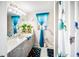 Cozy bathroom with a single sink vanity, bright lighting, blue accents, and a shower with glass doors at 22378 Peachland Blvd, Port Charlotte, FL 33954