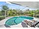 Beautiful screened-in pool area with lounge chairs and mature trees offering privacy in this outdoor oasis at 22378 Peachland Blvd, Port Charlotte, FL 33954