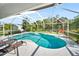 Inviting screened-in pool surrounded by lush greenery and equipped with lounge chairs for relaxation and enjoyment at 22378 Peachland Blvd, Port Charlotte, FL 33954