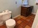 Small bathroom with a toilet, vintage vanity, and terra cotta flooring at 2451 Loma Linda St, Sarasota, FL 34239