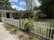 Charming home featuring a white picket fence, mature trees and partially xeriscaped front yard at 2451 Loma Linda St, Sarasota, FL 34239