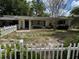 Quaint single-story home with a white picket fence and mature trees in the front yard at 2451 Loma Linda St, Sarasota, FL 34239