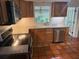 A kitchen features wood cabinets, stainless steel appliances, tile floors, and a window at 2451 Loma Linda St, Sarasota, FL 34239