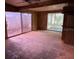 Large living room with wood paneling, sliding glass doors, and an unfinished concrete floor at 2451 Loma Linda St, Sarasota, FL 34239