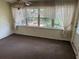 Enclosed sunroom with large windows, wood paneling, and a ceiling fan at 2451 Loma Linda St, Sarasota, FL 34239
