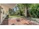 Lush backyard featuring a brick patio and a mature tree, offering ample space for outdoor enjoyment at 2462 Hyde Park St, Sarasota, FL 34239