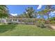 Charming single-story home featuring a well-manicured lawn and welcoming front entrance with lots of shade trees at 2462 Hyde Park St, Sarasota, FL 34239