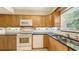 Kitchen featuring wooden cabinets, modern appliances, and tiled backsplash and floors at 2462 Hyde Park St, Sarasota, FL 34239