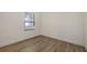 Bedroom with wood-look flooring, a window with blinds, and neutral walls, creating a serene space at 248 Altamura Cir, Nokomis, FL 34275