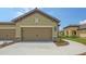 Beige two-car garage with stone accents and manicured landscaping in front of a Florida home at 248 Altamura Cir, Nokomis, FL 34275