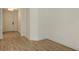 Light-filled hallway with wood-look floors, white trim, and a white door with black hardware at 248 Altamura Cir, Nokomis, FL 34275