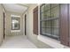 Covered front porch with neutral colors, brown shutters, and multi-paned windows at 248 Altamura Cir, Nokomis, FL 34275