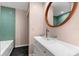 Bathroom with turquoise tiling, glass vessel sink, and a decorative oval mirror at 2504 Tanglewood Dr, Sarasota, FL 34239