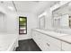 Bright bathroom with double sinks, large mirrors, and a window that provides natural light at 2504 Tanglewood Dr, Sarasota, FL 34239