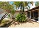 Picturesque courtyard with tropical palms, red tile roof, and natural light at 2504 Tanglewood Dr, Sarasota, FL 34239