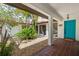 Charming courtyard featuring a blue door, red tile roof, and lush palm trees at 2504 Tanglewood Dr, Sarasota, FL 34239