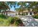 Beautiful home exterior with mature landscaping, red tile roof, and a spacious driveway at 2504 Tanglewood Dr, Sarasota, FL 34239