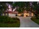 Inviting home exterior showcasing a red tile roof, arched windows, and a curved driveway framed by mature trees at 2504 Tanglewood Dr, Sarasota, FL 34239