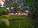 Charming home with a fenced yard, mature trees, lush lawn, and whimsical treehouse at 2504 Tanglewood Dr, Sarasota, FL 34239