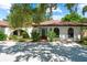 Inviting front entrance featuring a vibrant blue door, red tile roof, and lush foliage at 2504 Tanglewood Dr, Sarasota, FL 34239