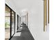 Bright hallway with black tile floors, modern lighting, and courtyard views at 2504 Tanglewood Dr, Sarasota, FL 34239