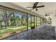 This screened-in lanai features stone tile floors and views of the backyard and canal at 2504 Tanglewood Dr, Sarasota, FL 34239