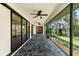 This screened-in lanai features stone tile floors and views of the backyard and treehouse at 2504 Tanglewood Dr, Sarasota, FL 34239