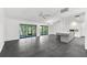 Living room area showing sliding glass doors, tile floor, chandelier, and kitchen island with barstool seating at 2504 Tanglewood Dr, Sarasota, FL 34239