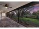 Spacious screened-in patio features brick flooring and expansive views of the well-maintained yard and waterfront at 2504 Tanglewood Dr, Sarasota, FL 34239