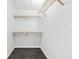 A simple walk-in closet with wooden racks and shelving for organized storage at 2504 Tanglewood Dr, Sarasota, FL 34239