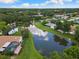 Scenic aerial view of homes backing onto a tranquil pond surrounded by lush greenery and blue skies at 2559 Wood Oak Dr, Sarasota, FL 34232