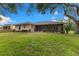 Well-maintained backyard with lush green lawn, mature trees, and a cozy screened lanai at 2559 Wood Oak Dr, Sarasota, FL 34232