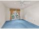 Bright bedroom featuring blue carpeting, a window, and glass paneled doors at 2559 Wood Oak Dr, Sarasota, FL 34232