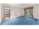 Well-lit bedroom featuring blue carpeting, a window, and glass paneled doors at 2559 Wood Oak Dr, Sarasota, FL 34232