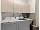 Efficient laundry room with modern washer and dryer, functional cabinets, and a utility sink at 2559 Wood Oak Dr, Sarasota, FL 34232