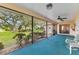 Relaxing screened porch featuring blue carpet flooring and peaceful views of the lush backyard at 2559 Wood Oak Dr, Sarasota, FL 34232