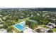 Aerial view of neighborhood amenities includes community pool, tennis courts, and recreational areas, surrounded by lush greenery at 2590 Floyd St, Sarasota, FL 34239