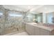 Beautiful bathroom featuring a glass enclosed shower with marble surround, dual vanity, and stylish finishes at 2590 Floyd St, Sarasota, FL 34239