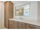 Modern bathroom boasts wood cabinets, sleek hardware, and a large illuminated mirror offering a contemporary spa-like feel at 2590 Floyd St, Sarasota, FL 34239