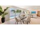 Elegant dining area with glass table, comfortable seating, and view of the outdoor pool at 2590 Floyd St, Sarasota, FL 34239