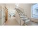 Bright, modern home entryway featuring a staircase with metal railing and wood stairs at 2590 Floyd St, Sarasota, FL 34239
