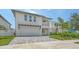 A modern two-story home with a two-car garage, second story balcony, and a paver driveway at 2590 Floyd St, Sarasota, FL 34239
