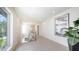Bright hallway features neutral tile flooring, modern railing, a large window, and stylish artwork for a contemporary design at 2590 Floyd St, Sarasota, FL 34239