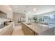 Modern kitchen featuring stainless steel appliances, a large island with marble countertops, and access to the pool area at 2590 Floyd St, Sarasota, FL 34239
