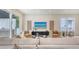 Bright living room with neutral furniture, beach artwork, seamless indoor-outdoor flow to covered patio at 2590 Floyd St, Sarasota, FL 34239