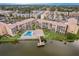 Aerial view of lakeside condo community with a swimming pool, clubhouse, and dock at 3635 Lake Bayshore Dr # J-410, Bradenton, FL 34205